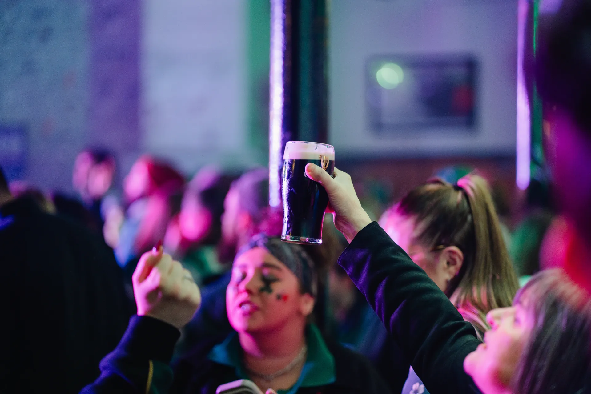 Creamy pint of Guinness raised high in the crowd at a Nortons Digbeth Christmas gig