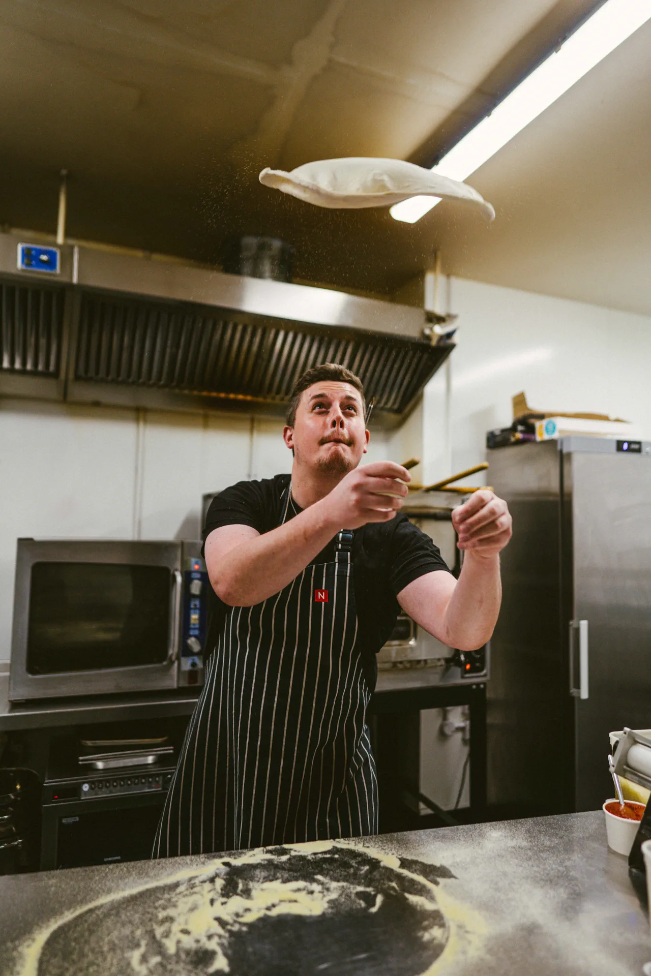 Nortons pizza chef tossing 24-hour fermented sourdough pizza base in the kitchen